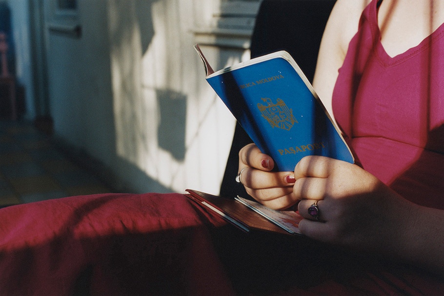 Woman in pink holding passport.