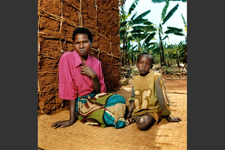 Boy sits on ground next to mother