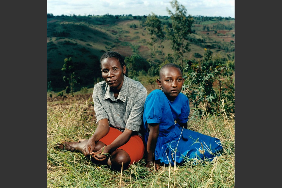 Mother and daughter sit in grass