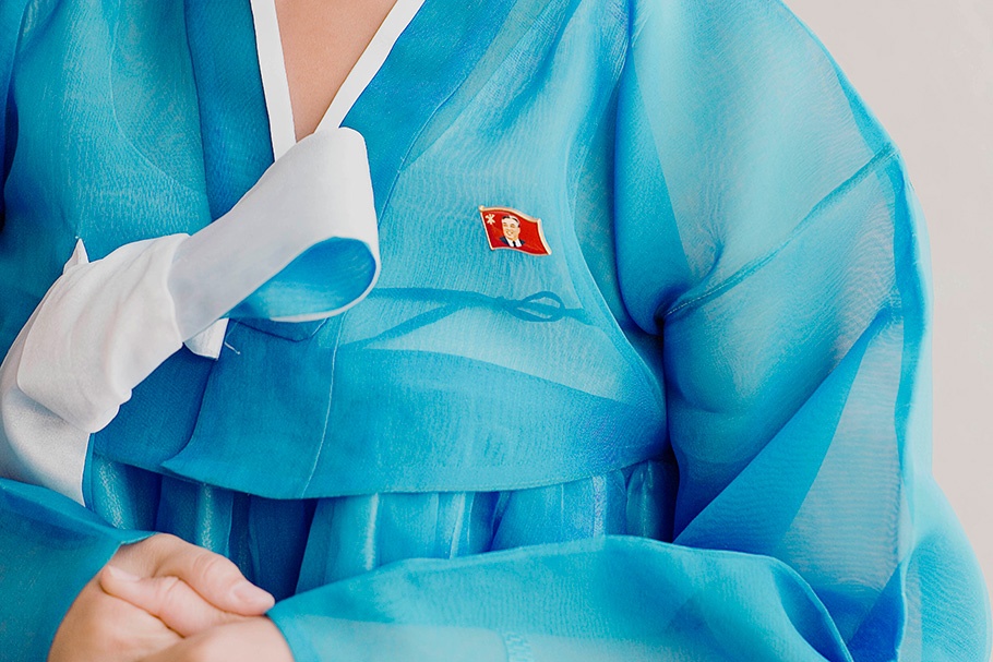 Woman in blue, wearing Kim Il Sung pin
