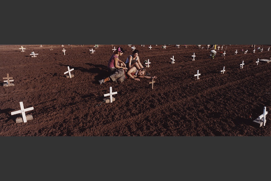 People in cemetery with white crosses.
