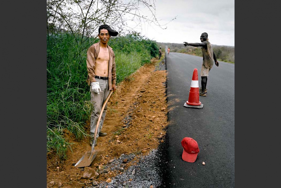 Men on road with traffic cone.