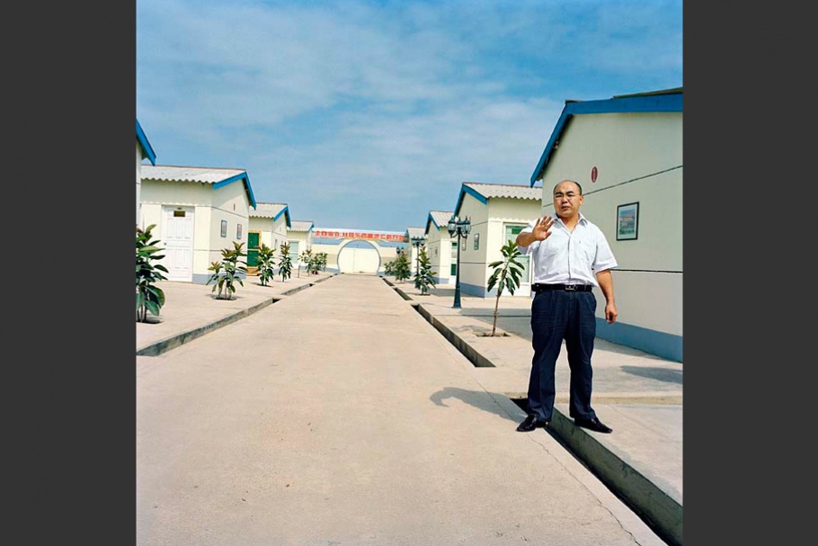 Man on street with white houses.