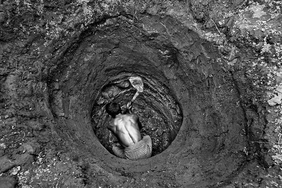 Man digging a hole, viewed from above.