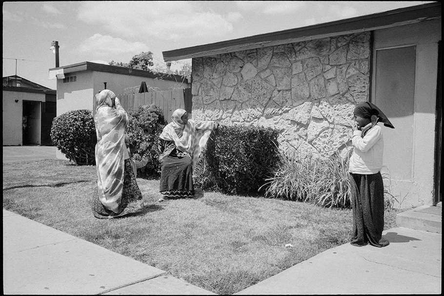 Three women outside of a home.