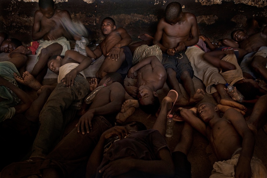 A group of men lying down in a tight space.