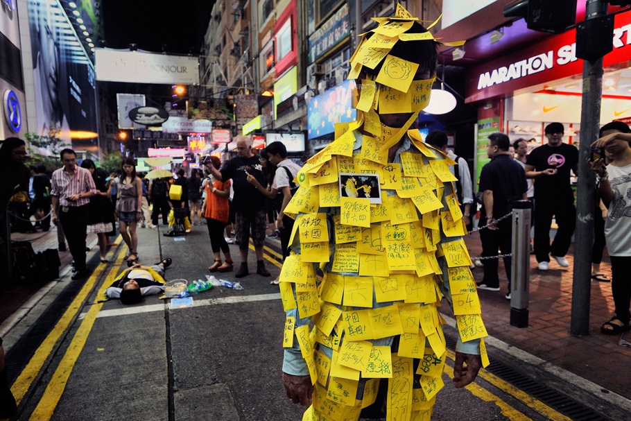Man standing in street covered in Post-it notes