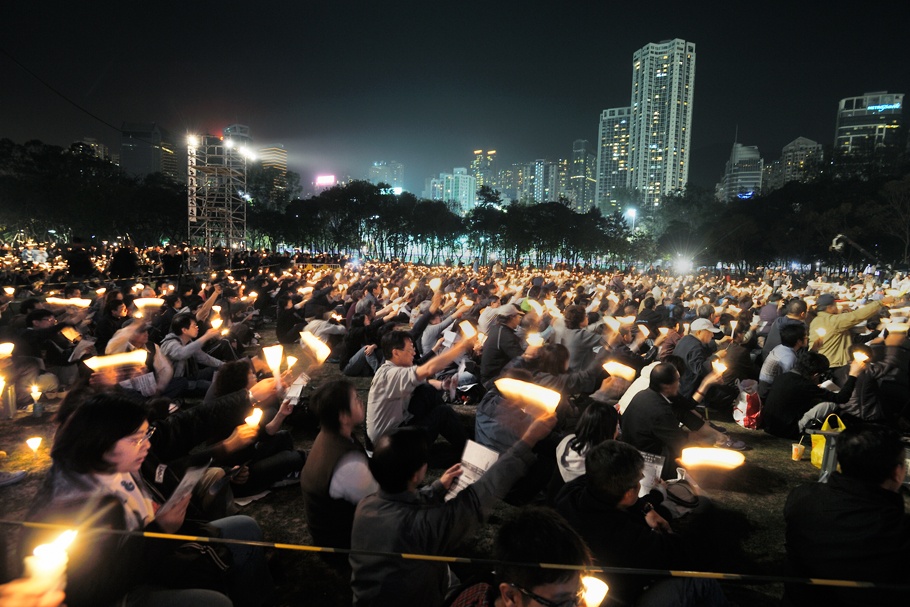Large crowd seated at a nighttime demonstration