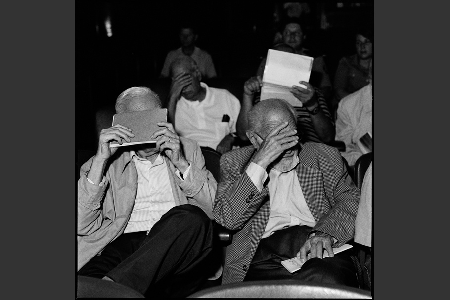 Seated men hiding their faces