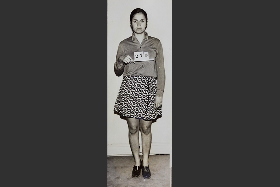 Mug shot of a woman standing and holding sign that reads “270.”