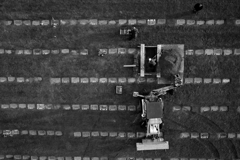 Aerial photograph of rows of headstones and open grave