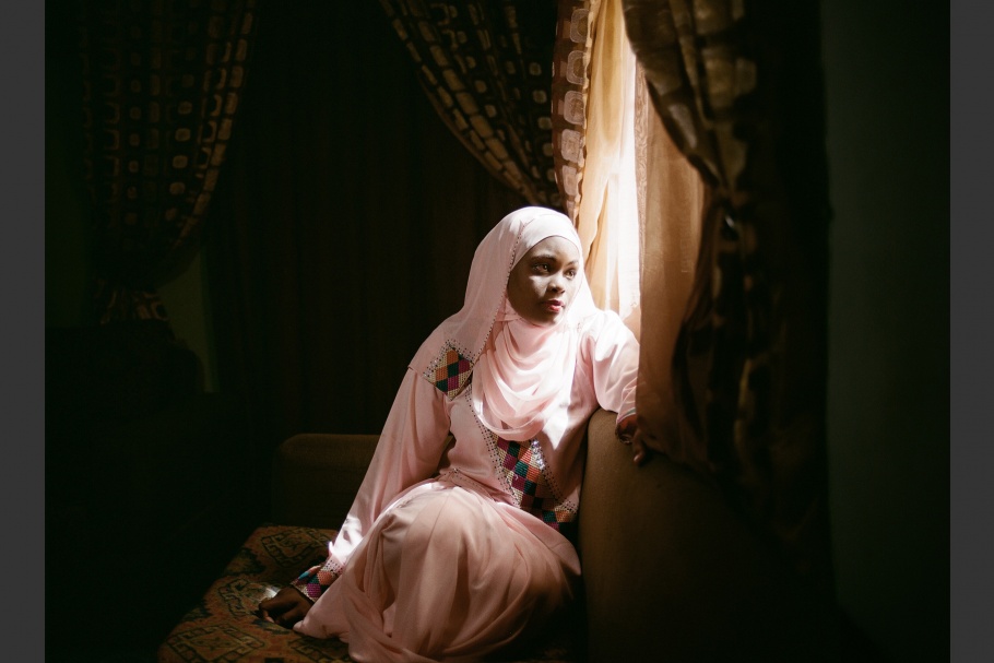 A Nigerian romance novelist sits at her window