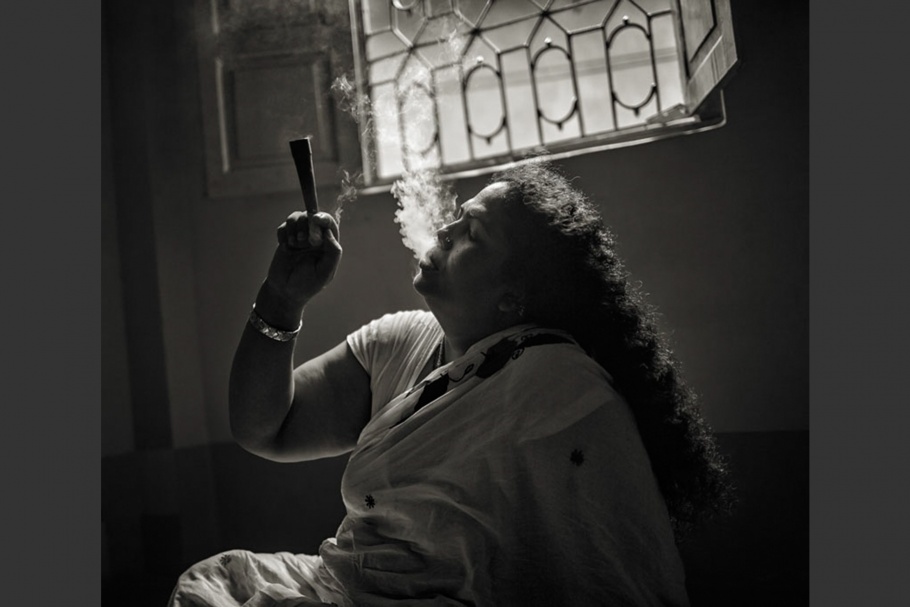 A Bangladeshi hijra woman smokes a pipe