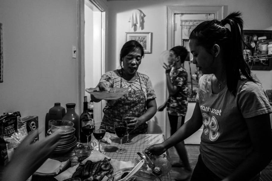 A woman and children in a kitchen.