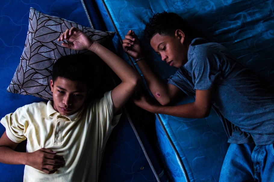 Two boys lying on mattresses