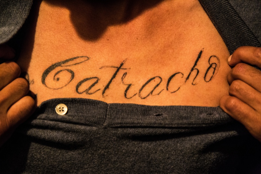 A tattoo on a chest that reads, "catracho"