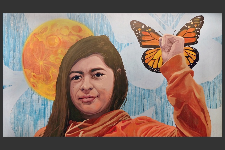 A mural of a woman with a fist up and a butterfly in the background