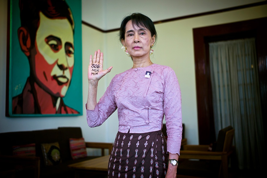 Aung San Suu Kyi raising her hand with writing on it.