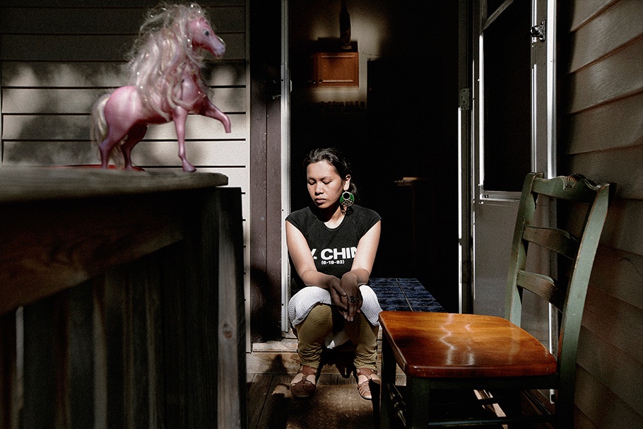 Girl sitting near a toy horse.