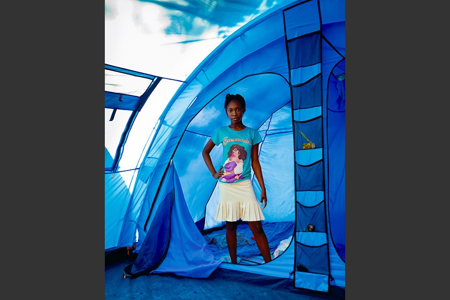 Girl standing at entrance to a tent.