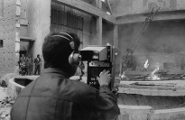 Panorama of a film set with a cameraman in the foreground.