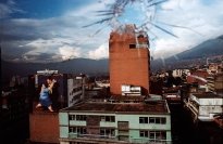 A cityscape viewed through glass with a bullet hole.