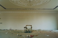 Ruined chair beneath an ornate ceiling.