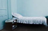 Empty bed with blue wall.