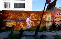 Cut-out figure of man pasted onto rusted and graffiti-covered wall