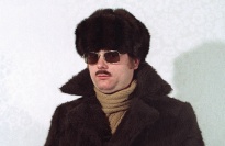 Man with fur coat and hat, wearing sunglasses