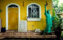A small replica of the Statue of Liberty in front of a house